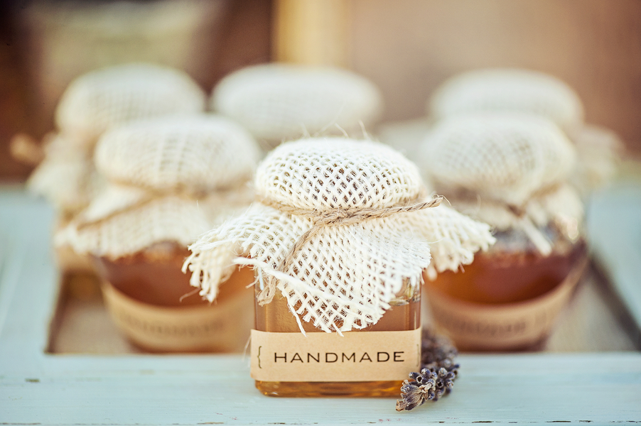 handmade honey jars with cheesecloth tops tied with twine and a sprig of lavender