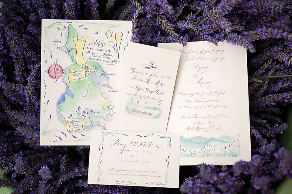 wedding invitation suite with hand-illustrated watercolor map of Salt Spring Island and calligraphy script cards displayed on fresh lavender