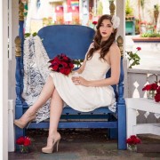 Bride sitting in gazebo in Balboa Park with red roses