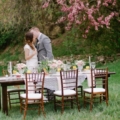 bride and groom standing infront of breakfast table in the countryside