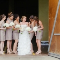 bride with bridesmaids stading infront of barn door at montaluce winery