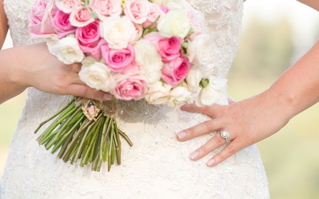 Close-up of pink and white rose bouquet showing mix of hot pink, blush, and ivory roses with twine-wrapped stems