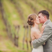 bride and groom kissing in vinyard