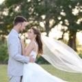 bride-and-groom-with-brides-veil-blowing-in-the-windwq