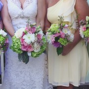 bridesmaids in pastel colors holding wild flower  green pink and white bouquets