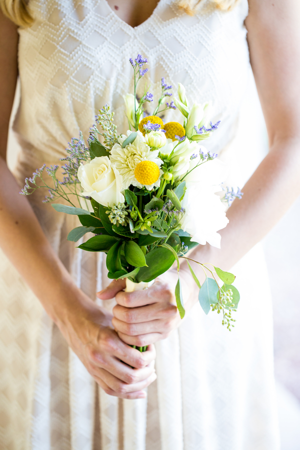 Bridesmaid holding petite bouquet with cream roses, yellow billy balls, lavender sprigs, and eucalyptus