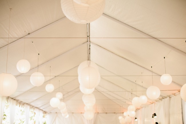 White Paper Lanterns hang from a tent ceiling 