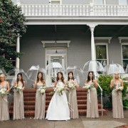 7 Bride with bridesmaids standing in a line holding clear umbrellas at PATRICK RANCH MUSEUM
