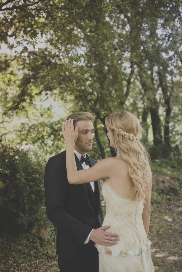 Bride with blonde hair pulled back at the crown beneath a full floral wreath, the rest flowing long down her back