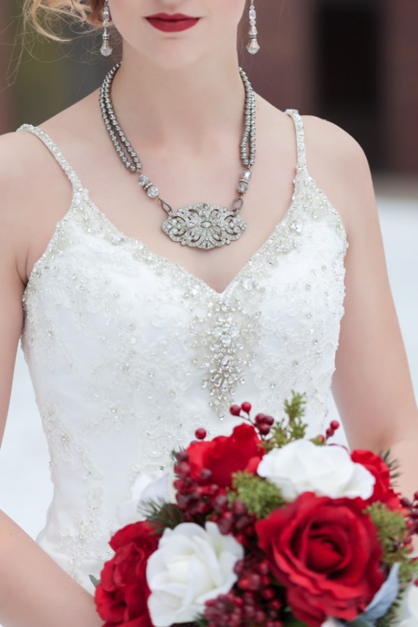 Bride in beaded spaghetti-strap white lace sheath gown with deep red lips at winter wonderland styled shoot in Minneapolis