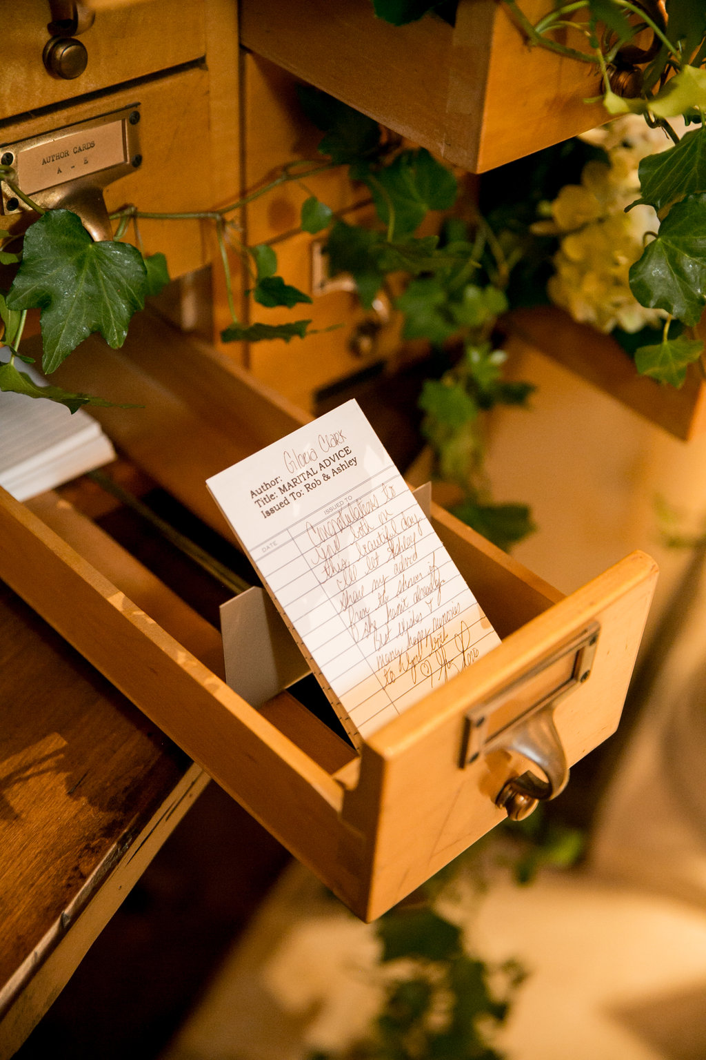 Library book borrowing cards used as wedding guest book alternative at literary themed wedding at Bella Collina with guests writing marriage advice