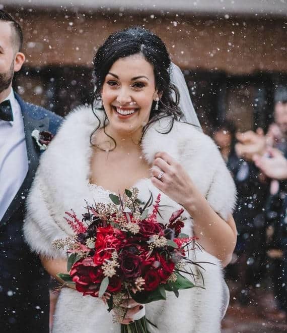 Bride wearing a faux fur wrap for winter wedding accessory