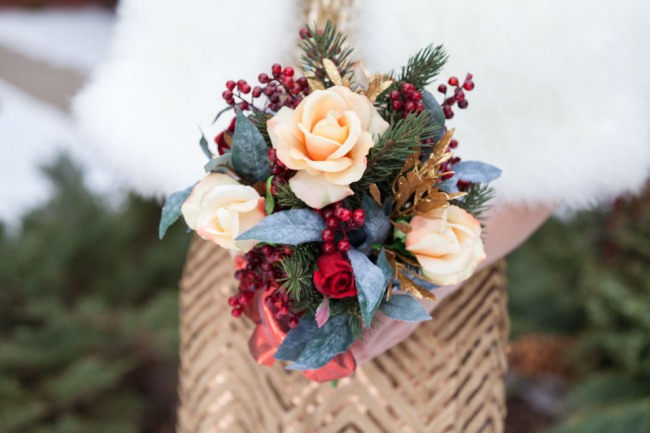 Bridesmaids holding Christmas themed bouquet and wearing a gold dress 