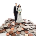 plastic bride and groom on a pile of coins ft