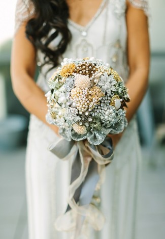 bride carrying a silver broach bouquet