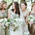 bride standing with bridesmaids wearing glittery gowns