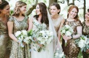 bride standing with bridesmaids wearing glittery gowns