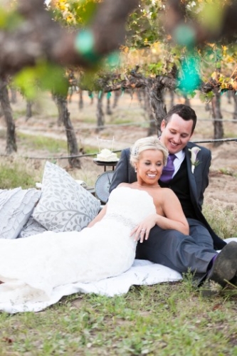 bride-and-groom-relax-on-picnic-blanket