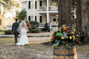 newlyweds walk towards plantation house