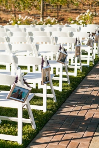 photos as aisle markers hang on white wedding ceremony chairs