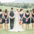 bridal party in vineyard with bride looking over shoulder