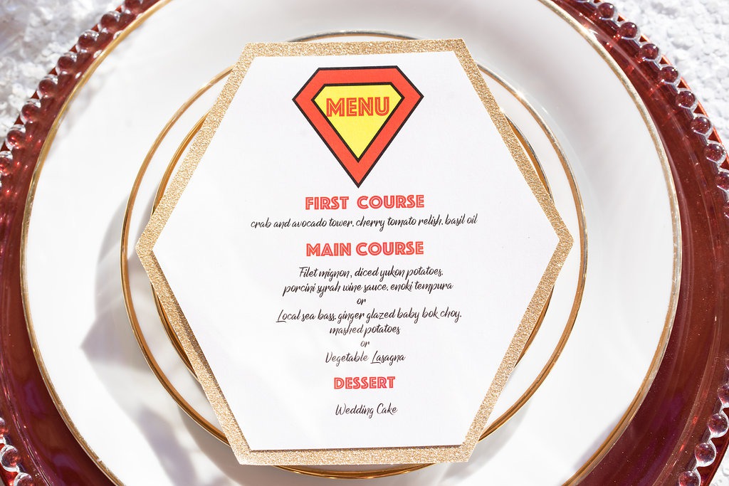 Hexagonal gold-glitter menu card reading MENU with first course, main course, and dessert on a white plate