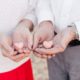 couple each hold heart macaroon in their hands