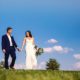 newlyweds with blue sky backdrop
