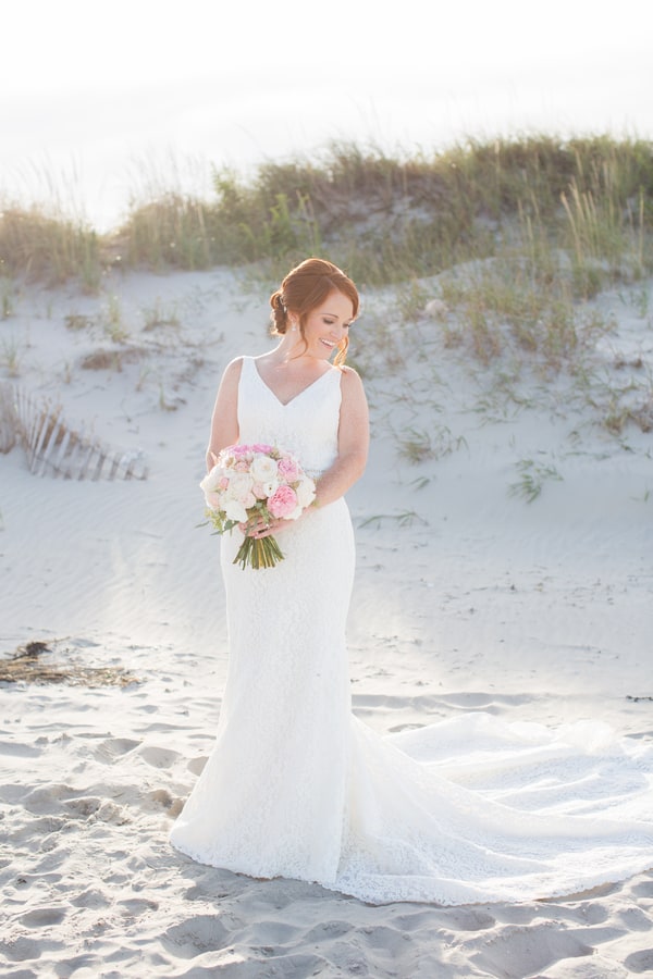 Bride portrait on sand dunes in Pronovias V-neck fitted lace wedding dress