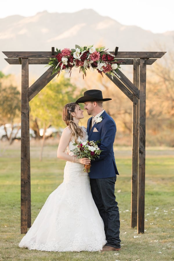 newlyweds-portrait-wooden-arch-cowboy-hat