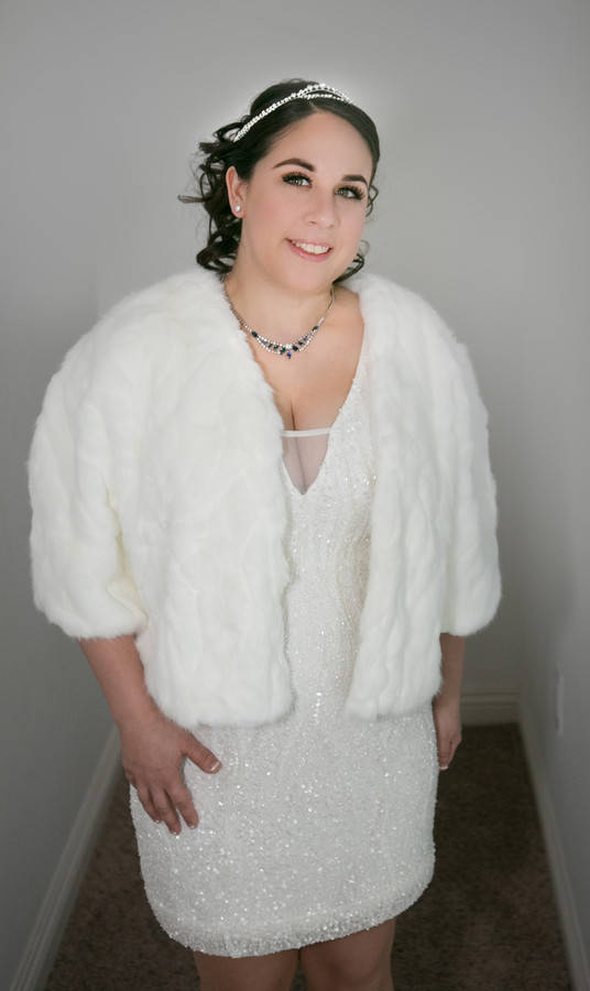 Bride in white sequin mini dress with fur bolero jacket, glamorous bridal portrait