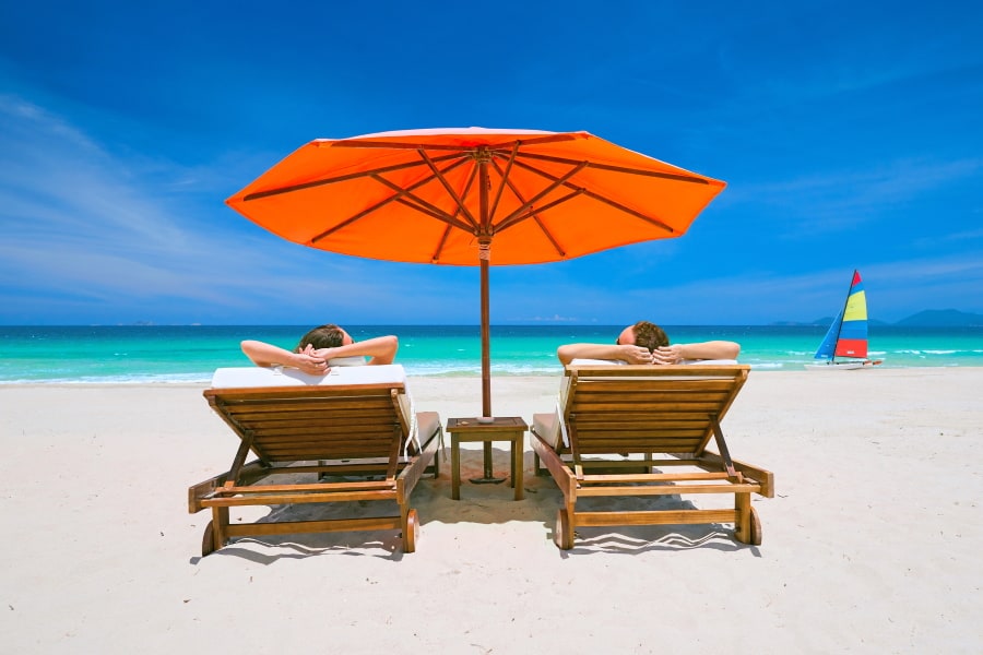 reclining chairs on Roatan sandy beach with umbrella