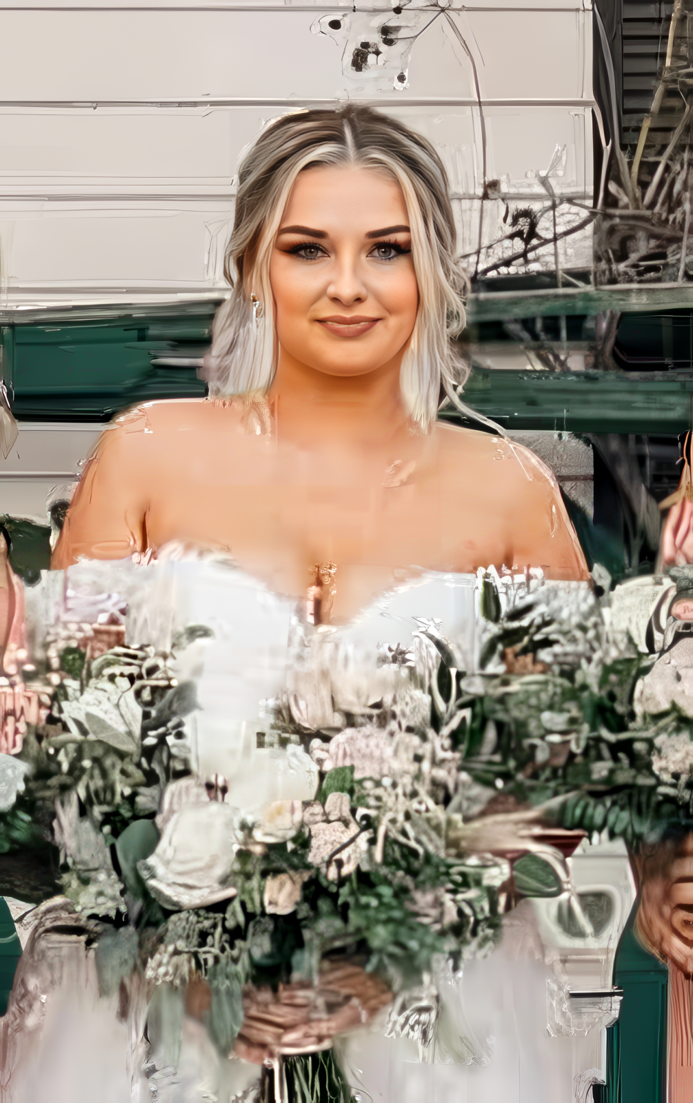 A woman in a white dress holds a large bouquet of white and green flowers, standing outdoors at a historical ranch wedding in Ventura County.