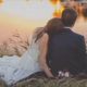 Bride and groom sit by pond