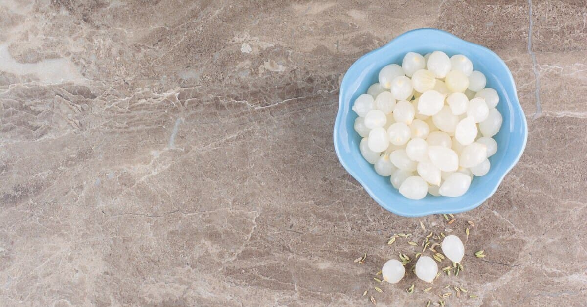 Peeled cloves of garlic placed on a stone table