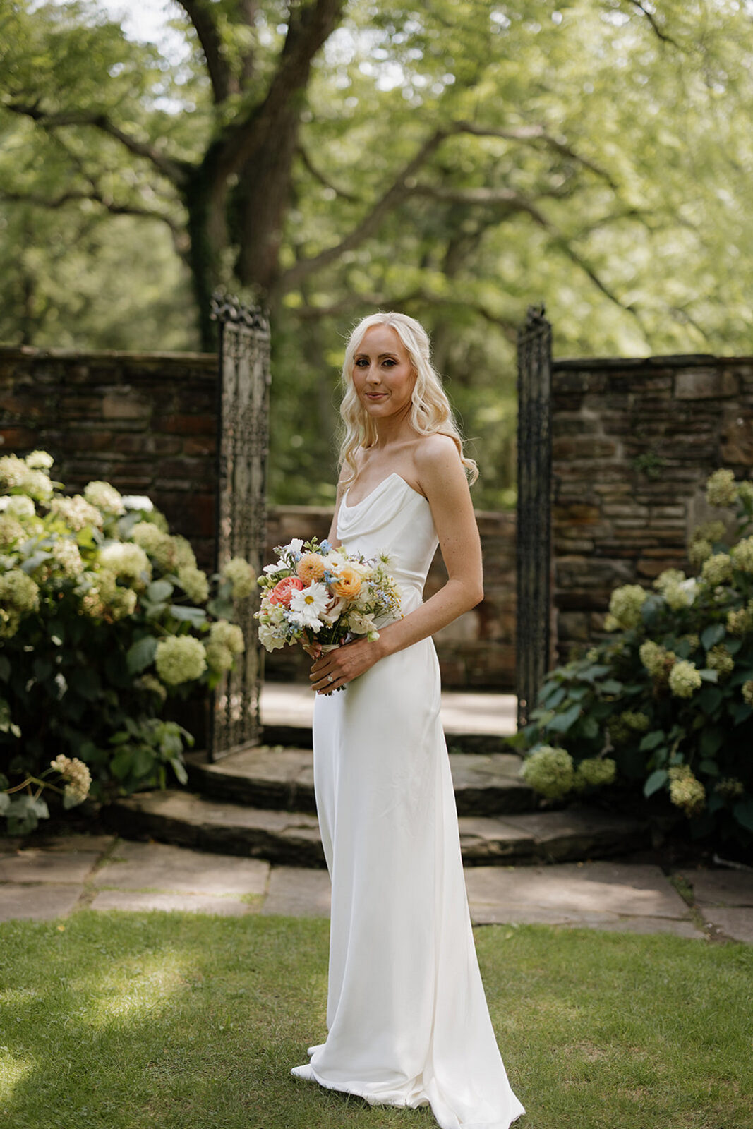 A woman in a white dress holding a bouquet of flowers.