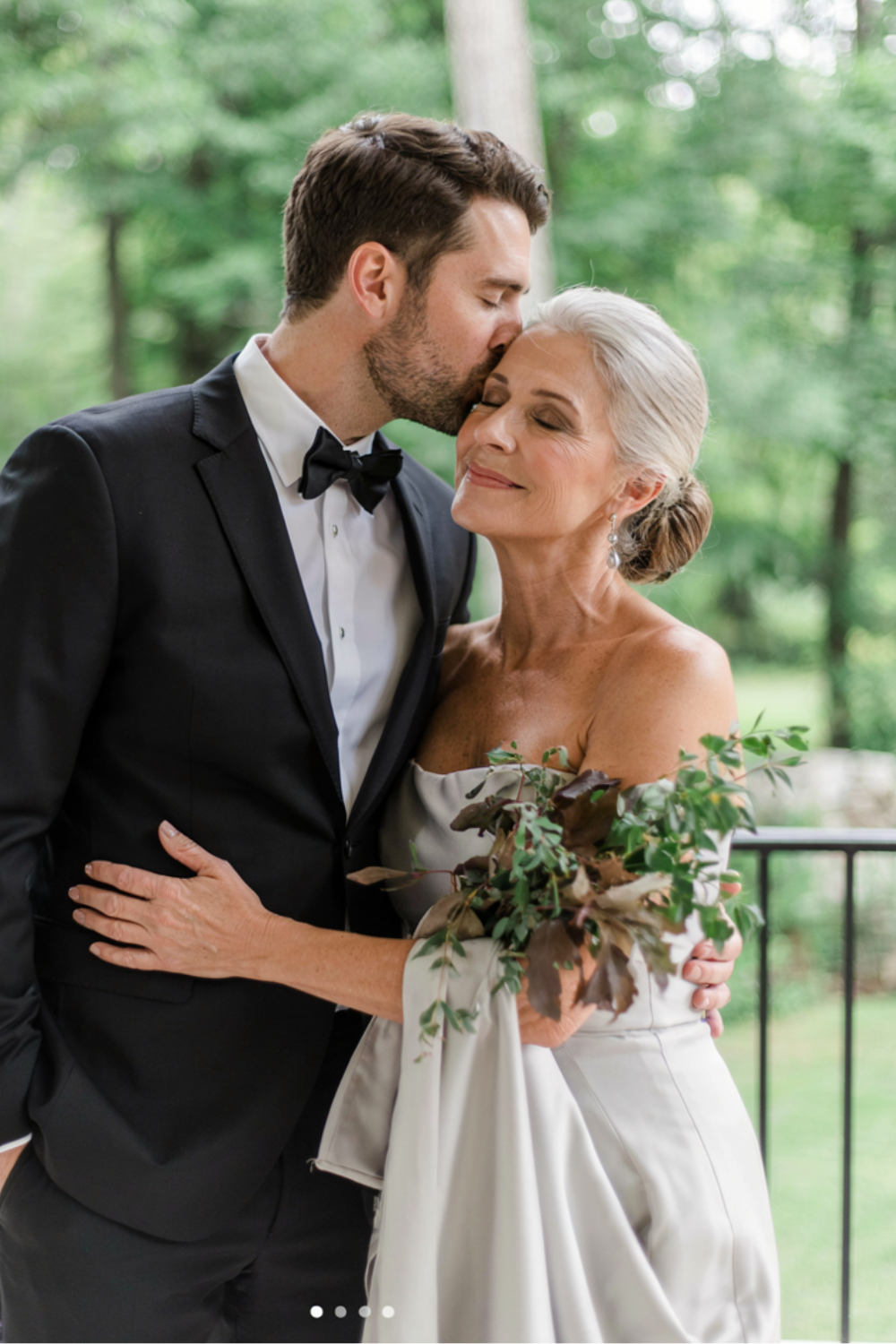 Silver hair swept back into a smooth low bun, worn with an off-shoulder ivory gown
