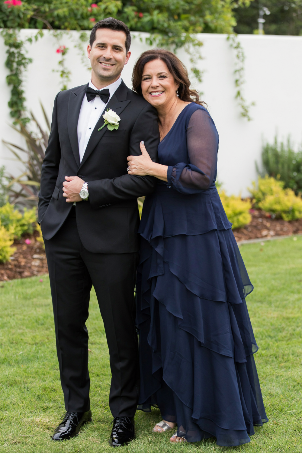 Brunette shoulder-length waves swept to one side, worn with a navy tiered chiffon gown