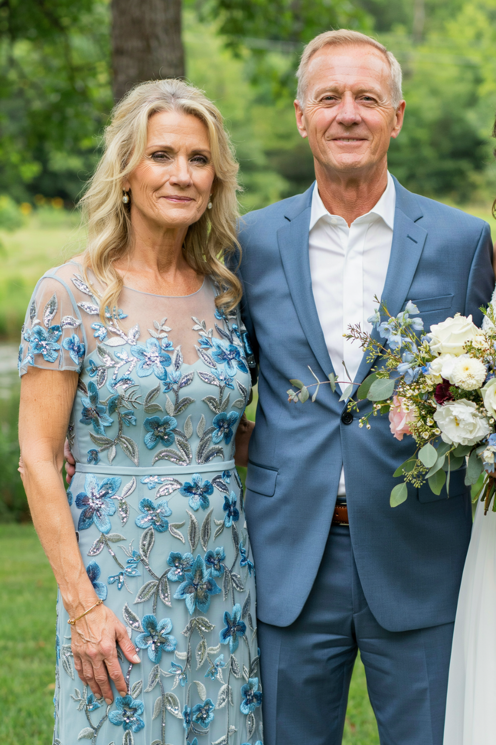 Long blonde loose waves worn down with soft face-framing layers and a blue floral appliqué dress