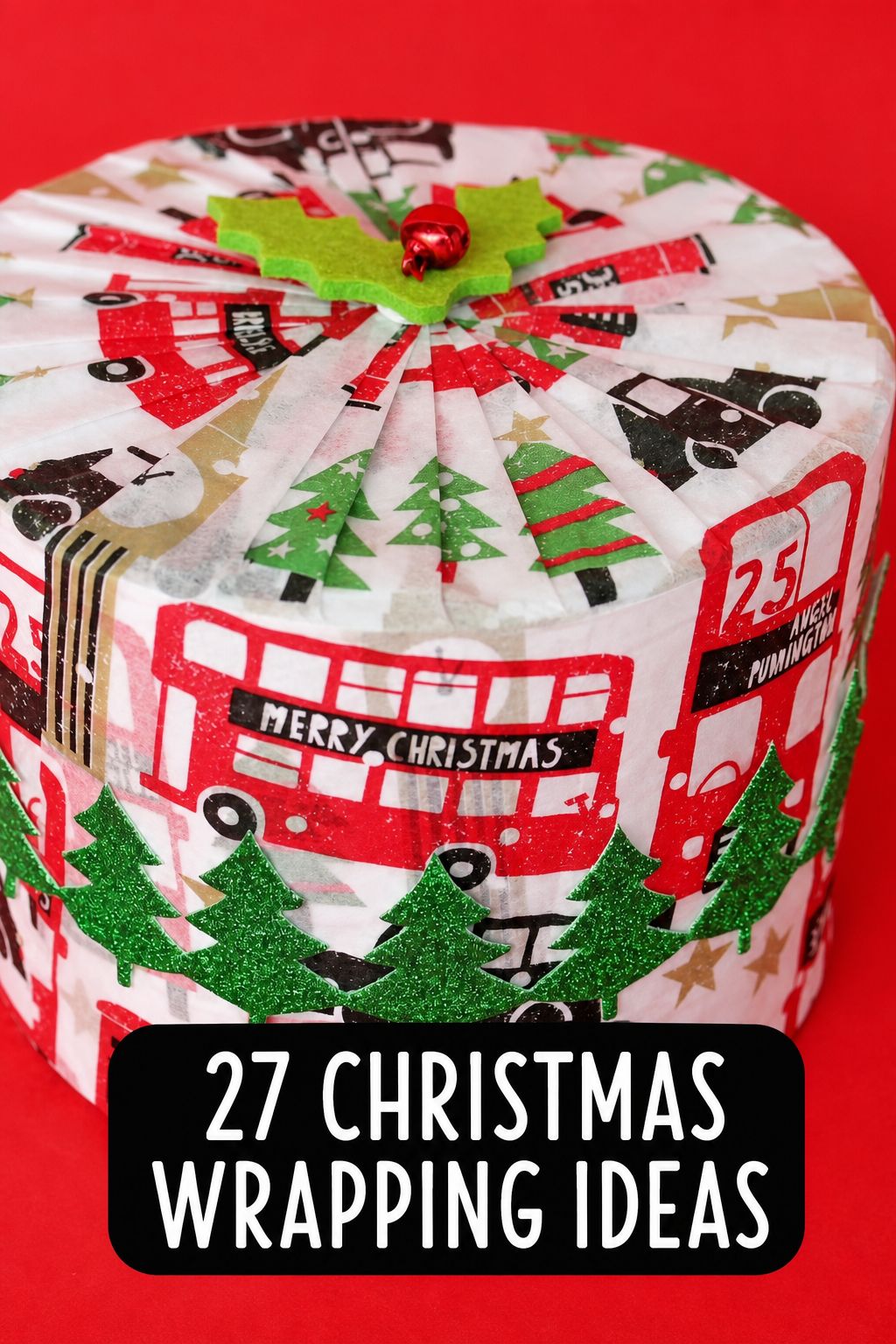 A Christmas gift wrapped with paper featuring red buses, green trees, and “Merry Christmas,” with a small bell on top. Text reads: “27 Christmas Wrapping Ideas”—your go-to source for creative Christmas wrapping inspiration and step-by-step videos.