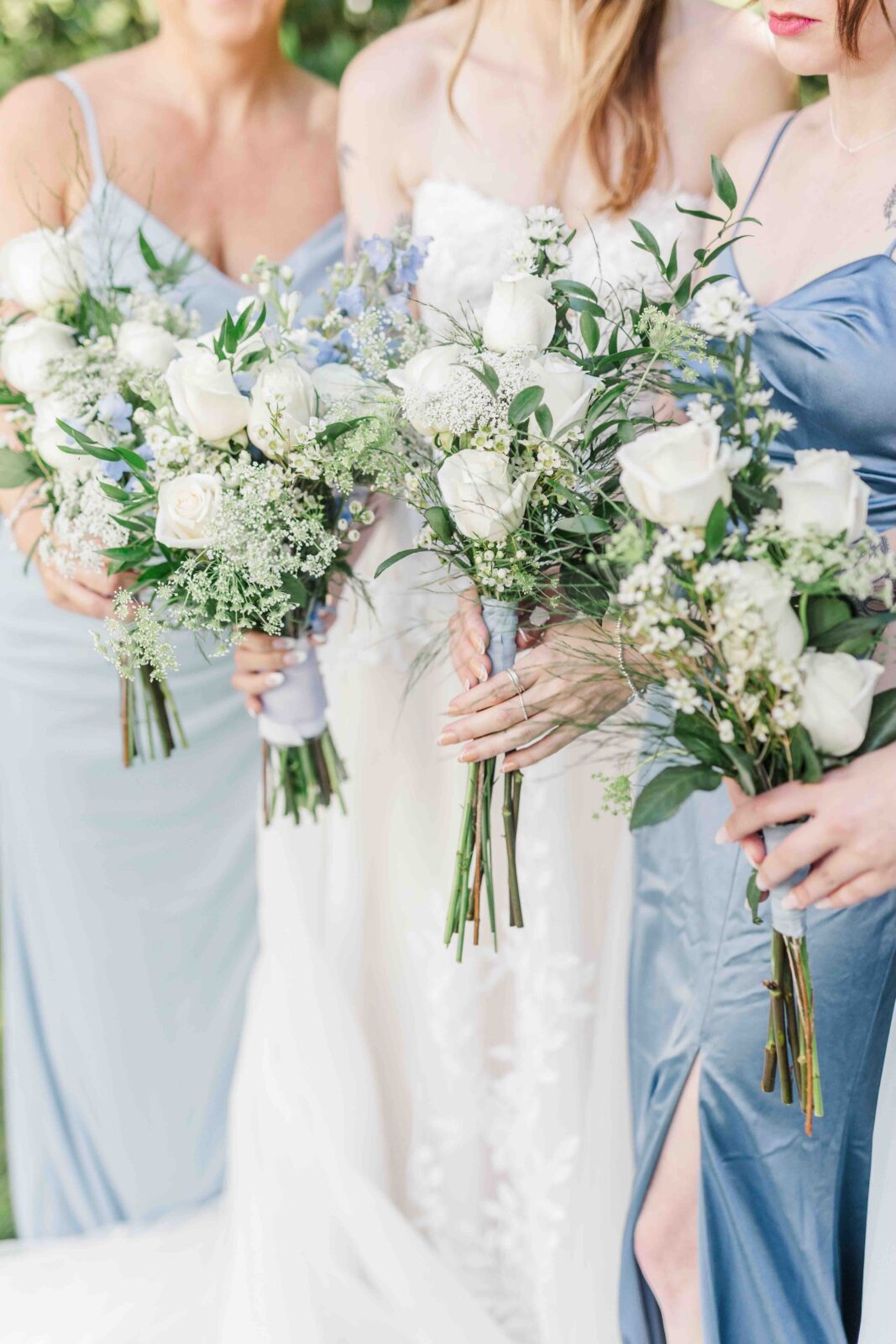 Bridesmaids holding white and greenery bouquets